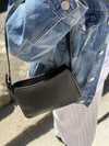 Bolso pequeño estructurado de piel napa negra con asa ajustable y diseño minimalista de la marca Hangover of Fashion, fabricado artesanalmente en España.