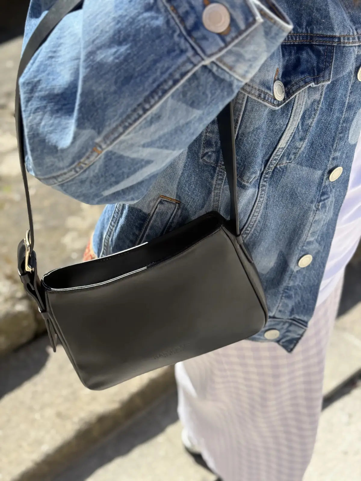 Bolso pequeño estructurado de piel napa negra con asa ajustable y diseño minimalista de la marca Hangover of Fashion, fabricado artesanalmente en España.