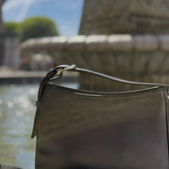 Bolso pequeño estructurado de piel napa negra con asa ajustable y diseño minimalista de la marca Hangover of Fashion, fabricado artesanalmente en España.