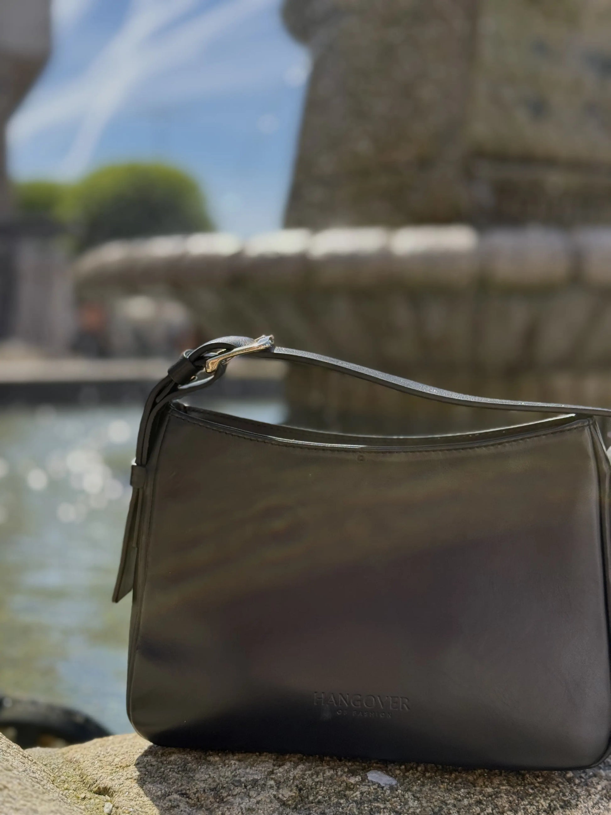 Bolso pequeño estructurado de piel napa negra con asa ajustable y diseño minimalista de la marca Hangover of Fashion, fabricado artesanalmente en España.