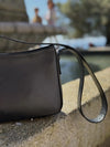 Bolso pequeño estructurado de piel napa negra con asa ajustable y diseño minimalista de la marca Hangover of Fashion, fabricado artesanalmente en España.