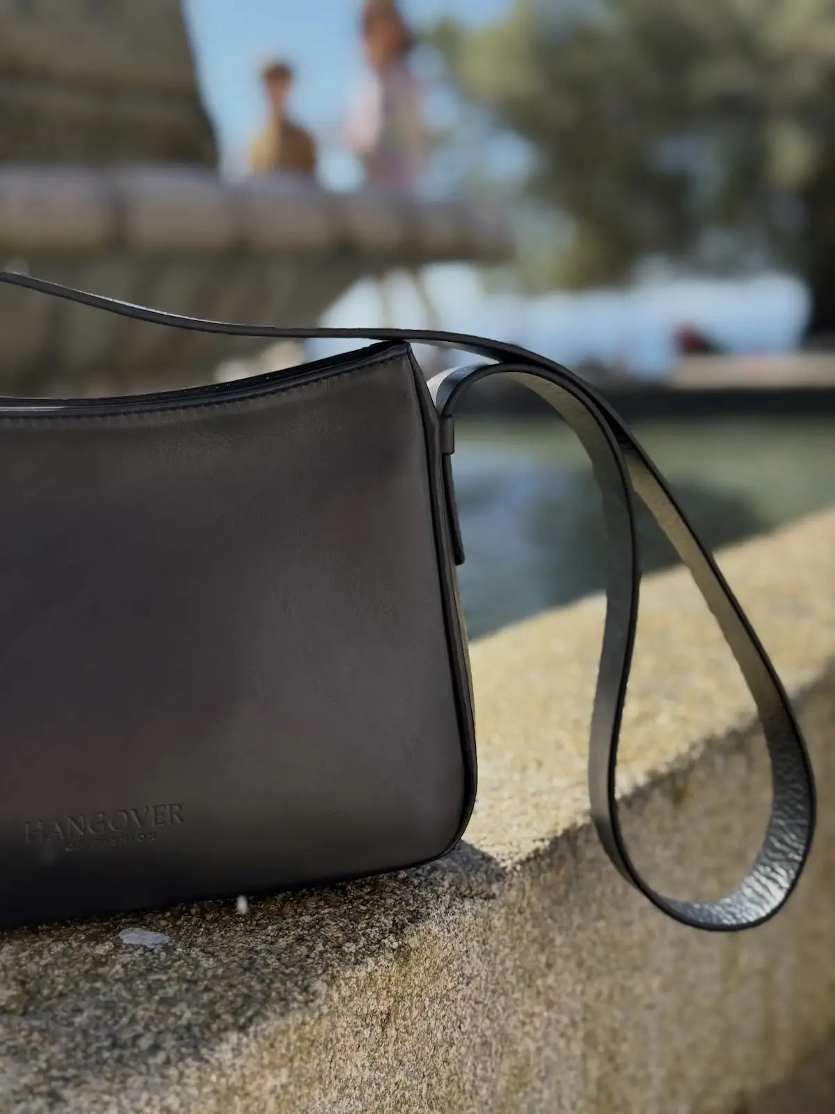 Bolso pequeño estructurado de piel napa negra con asa ajustable y diseño minimalista de la marca Hangover of Fashion, fabricado artesanalmente en España.