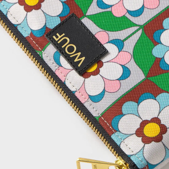 Pequeña funda plana con estampado geométrico multicolor, cierre de cremallera superior y etiqueta de cuero reciclado, modelo Kaleido Pouch de Wouf.