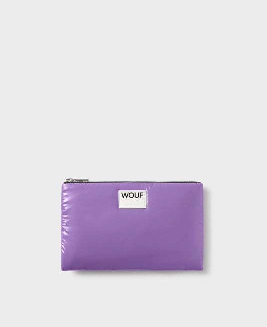 Pequeña funda plana con estampado color  lavanda, acabado brillante, cierre de cremallera superior y etiqueta de piel, modelo Lavender Pouch de Wouf.