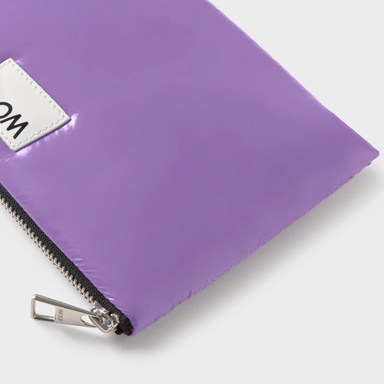 Pequeña funda plana con estampado color  lavanda, acabado brillante, cierre de cremallera superior y etiqueta de piel, modelo Lavender Pouch de Wouf.
