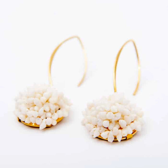 Pendientes largos Areoso Blanco de Montse Betanzos: conchas
marinas en ramillete marfil sobre gancho dorado, 4,5 cm.