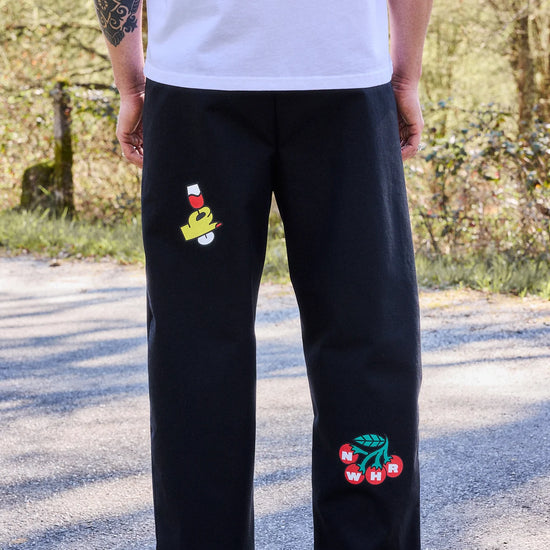 Pantalón tipo chino de color negro con corte relajado, dos pinzas en la parte frontal y cierre de doble botón, fabricado en algodón orgánico por NWHR.