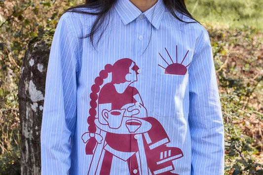 Camisa de rayas con corte boxy y un estampado artístico integral en tonos cálidos inspirado en el atardecer, fruto de la colaboración entre NWHR y Pruden.