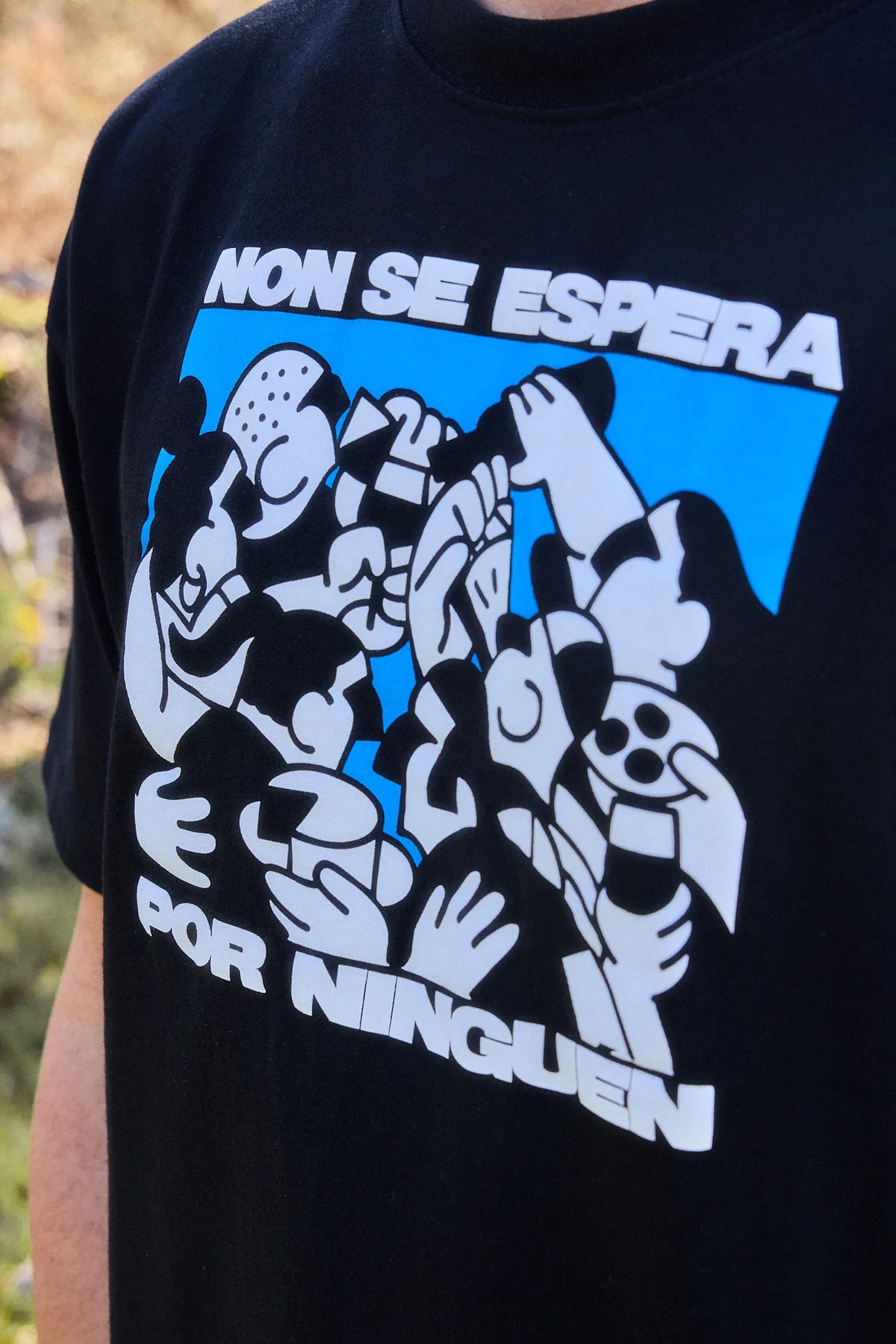 amiseta de color blanco roto con una ilustración artística en el pecho que muestra un rostro estilizado en trazos negros, diseñada por el artista Pruden para NWHR.