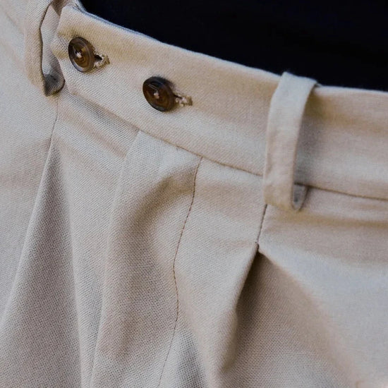 Pantalón tipo chino de color beige con corte relajado, dos pinzas en la parte frontal y cierre de doble botón, fabricado en algodón orgánico por NWHR.