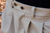 Pantalón tipo chino de color beige con corte relajado, dos pinzas en la parte frontal y cierre de doble botón, fabricado en algodón orgánico por NWHR.