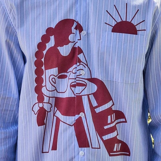 Camisa de manga corta con corte boxy y un estampado artístico integral en tonos cálidos inspirado en el atardecer, fruto de la colaboración entre NWHR y Pruden.