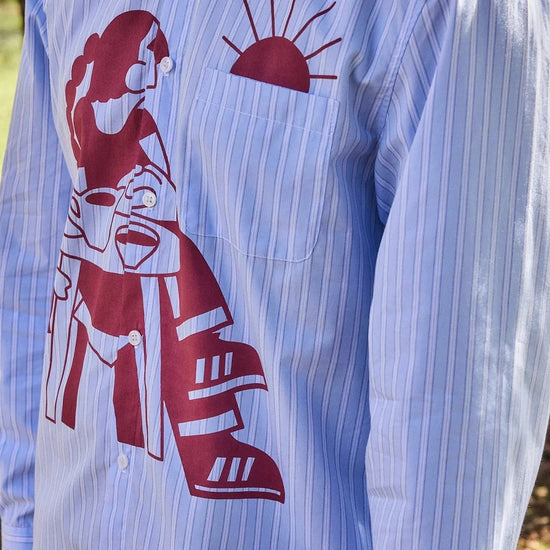 Camisa de manga corta con corte boxy y un estampado artístico integral en tonos cálidos inspirado en el atardecer, fruto de la colaboración entre NWHR y Pruden.
