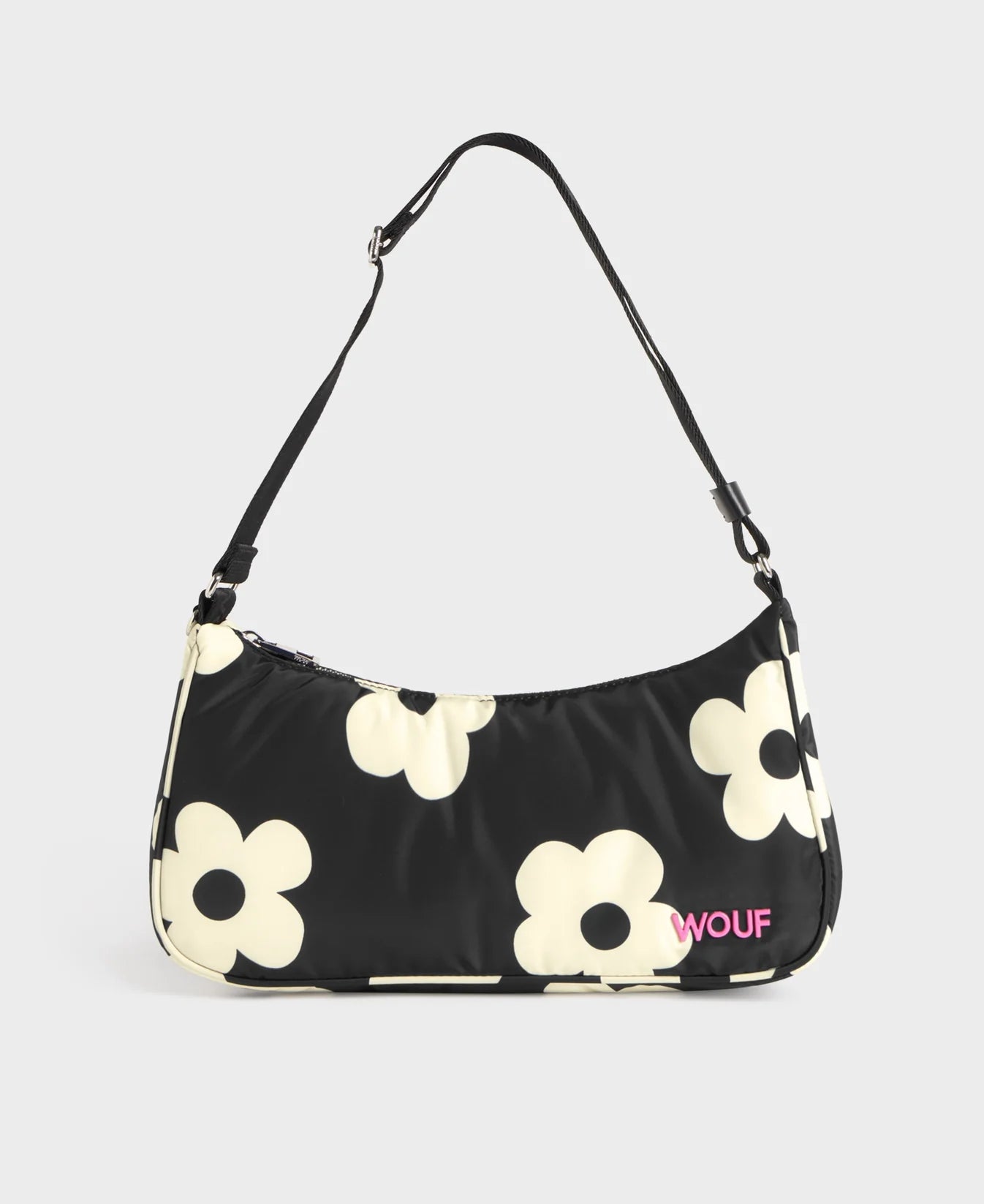 Bolso de hombro con estampado de margaritas blancas sobre fondo oscuro, logo metálico frontal, cremallera superior y correa ajustable, modelo Night Daisy de Wouf.