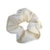 Coletero tipo scrunchie gigante de color blanco roto con capas de tela en forma de pétalos de flor anémona de la marca danesa By Stær.