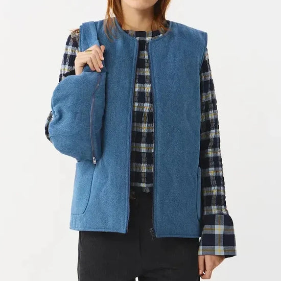Chaleco reversible para mujer de algodón orgánico, con una cara en tejido denim azul con bolsillos y otra cara en color negro liso, de la marca Suite13.
