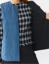 Chaleco reversible para mujer de algodón orgánico, con una cara en tejido denim azul con bolsillos y otra cara en color negro liso, de la marca Suite13.