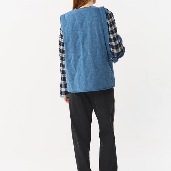 Chaleco reversible para mujer de algodón orgánico, con una cara en tejido denim azul con bolsillos y otra cara en color negro liso, de la marca Suite13.
