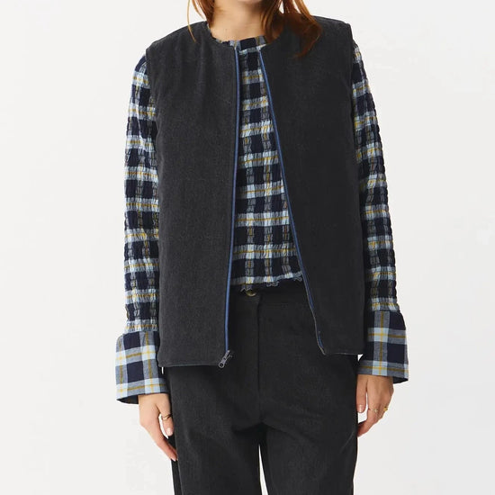 Chaleco reversible para mujer de algodón orgánico, con una cara en tejido denim azul con bolsillos y otra cara en color negro liso, de la marca Suite13.
