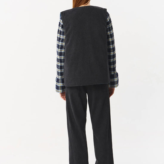 Chaleco reversible para mujer de algodón orgánico, con una cara en tejido denim azul con bolsillos y otra cara en color negro liso, de la marca Suite13.