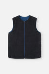 Chaleco reversible para mujer de algodón orgánico, con una cara en tejido denim azul con bolsillos y otra cara en color negro liso, de la marca Suite13.