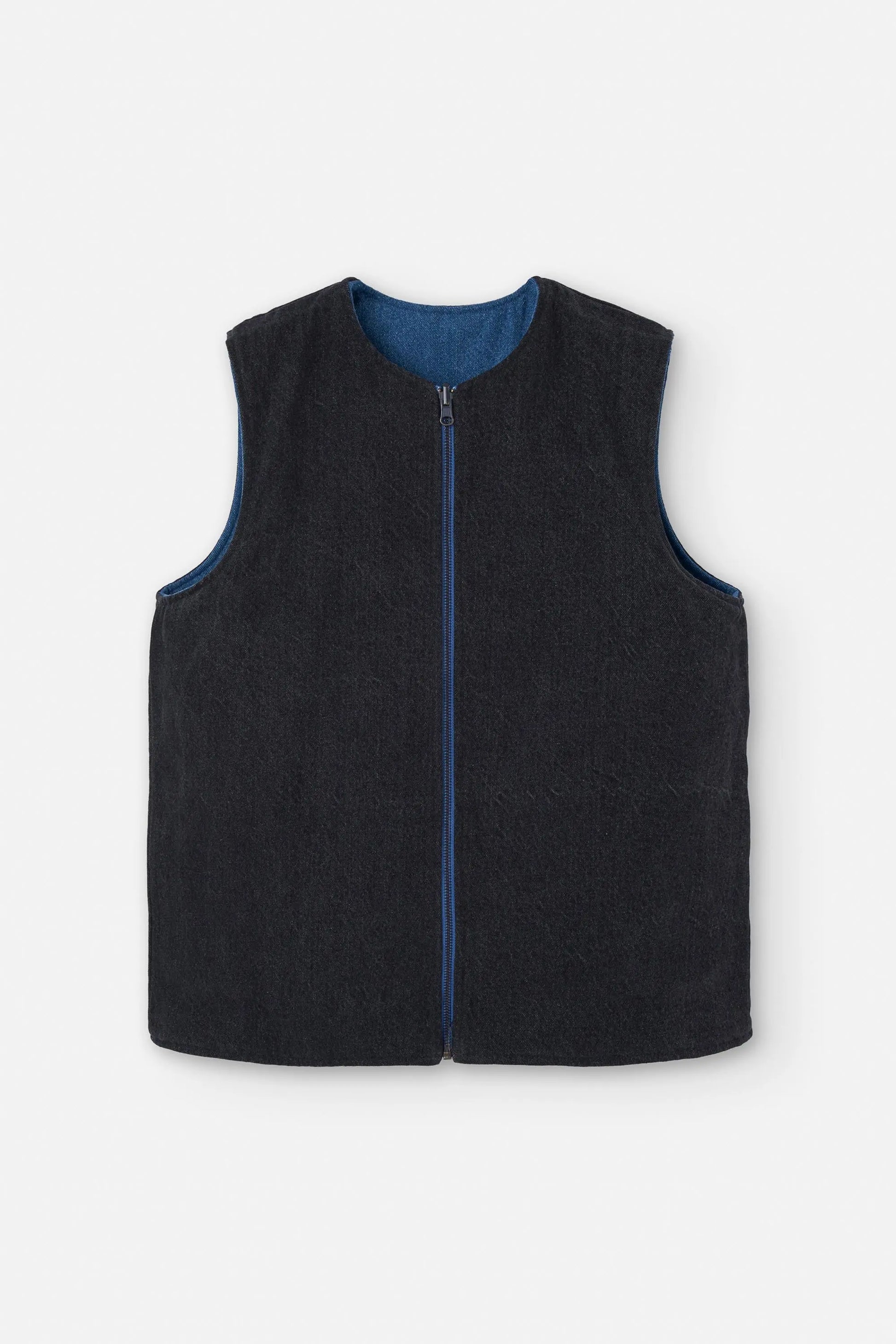 Chaleco reversible para mujer de algodón orgánico, con una cara en tejido denim azul con bolsillos y otra cara en color negro liso, de la marca Suite13.