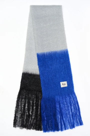 Bufanda de mohair con diseño de bloques de color en tonos contrastados, textura voluminosa de pelo suave y flecos largos hechos a mano en los extremos.