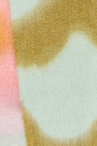 Bufanda de mohair voluminosa con diseño artesanal tie-dye en tonos cálidos y naturales, con flecos largos manuales y textura de pelo suave.