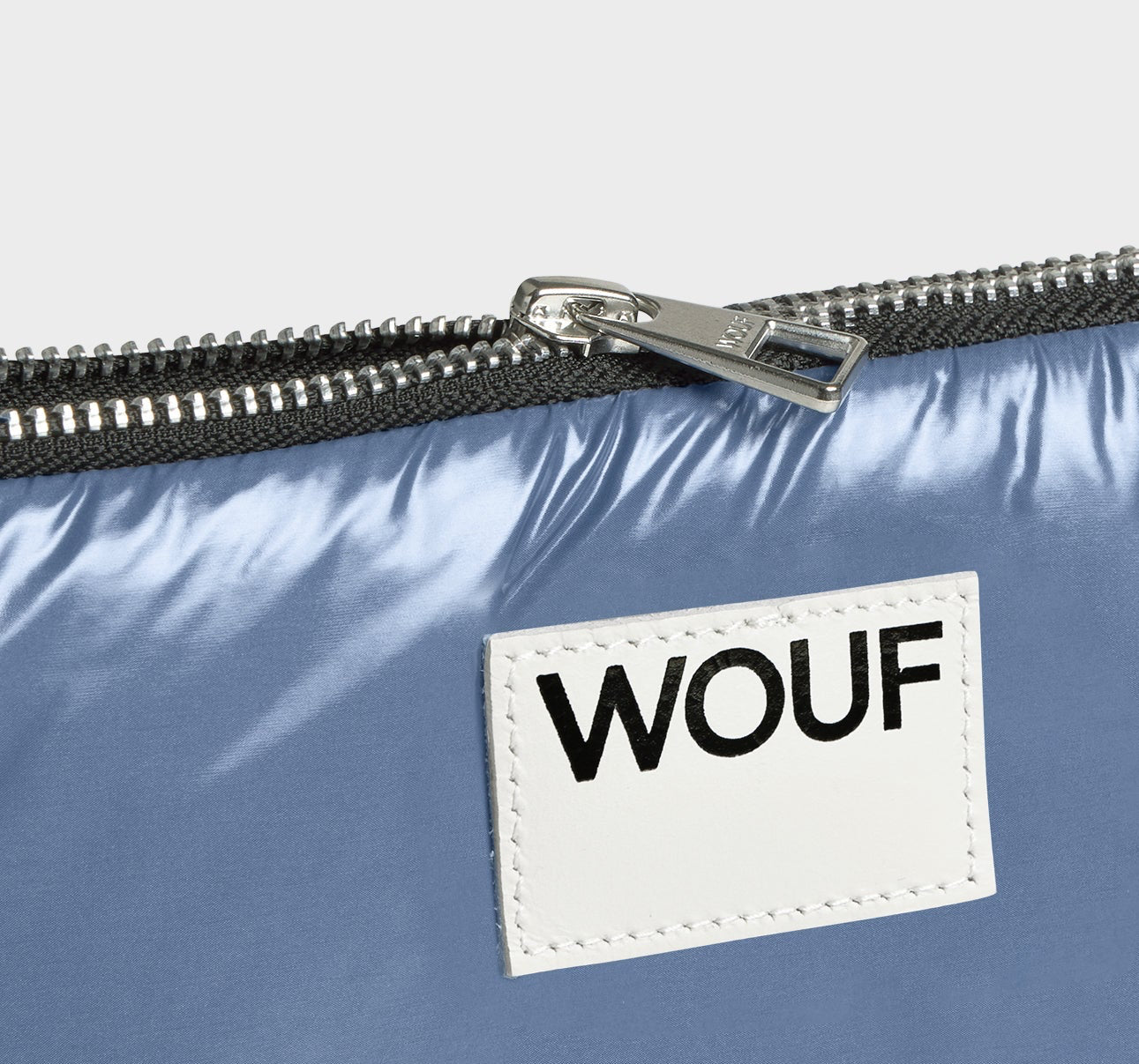 Funda protectora acolchada para portátil de 13 y 14 pulgadas con acabado brillante en color azul real, cierre de cremallera superior y etiqueta de cuero con el logo de Wouf.