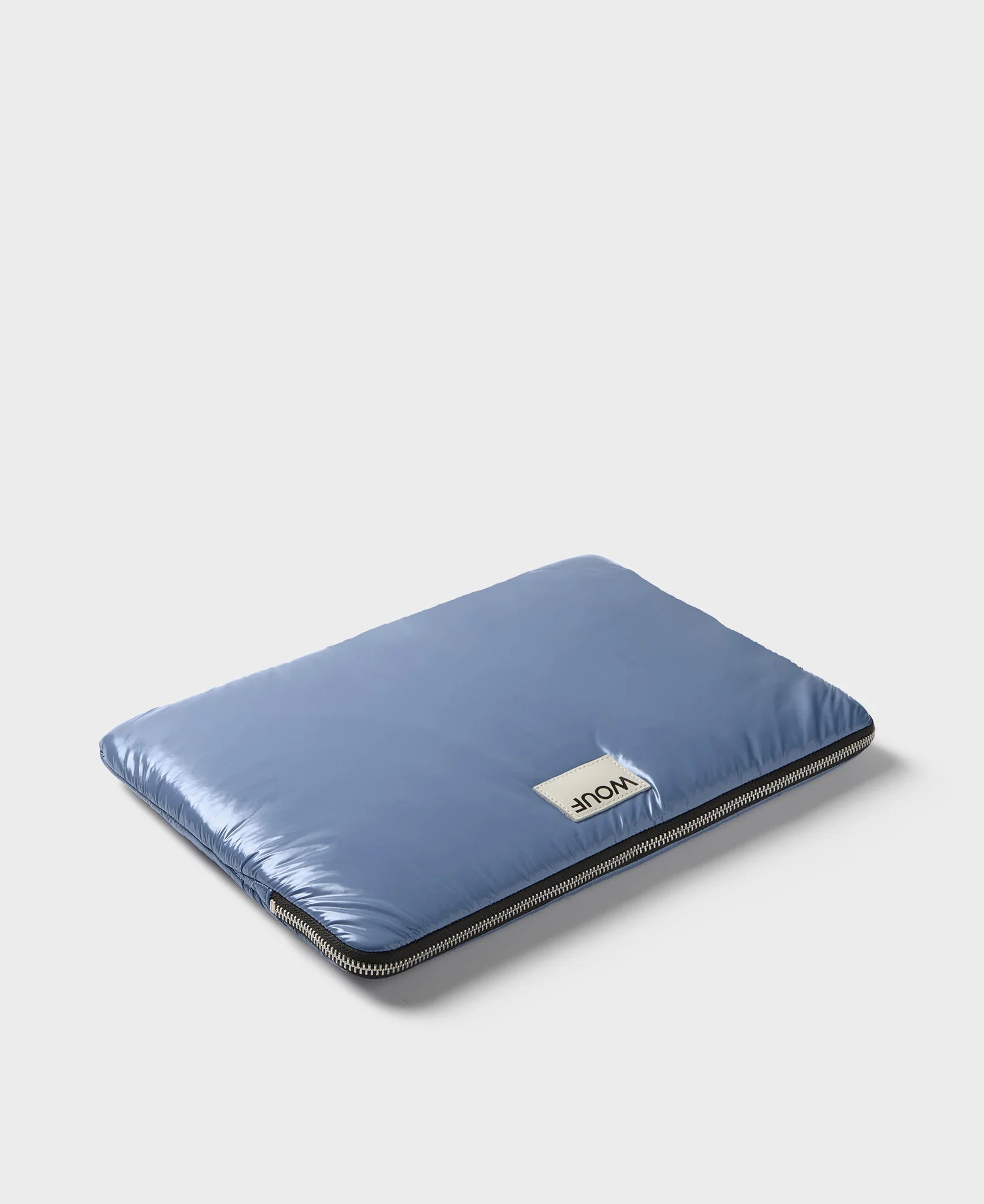 Funda protectora acolchada para portátil de 13 y 14 pulgadas con acabado brillante en color azul real, cierre de cremallera superior y etiqueta de cuero con el logo de Wouf.