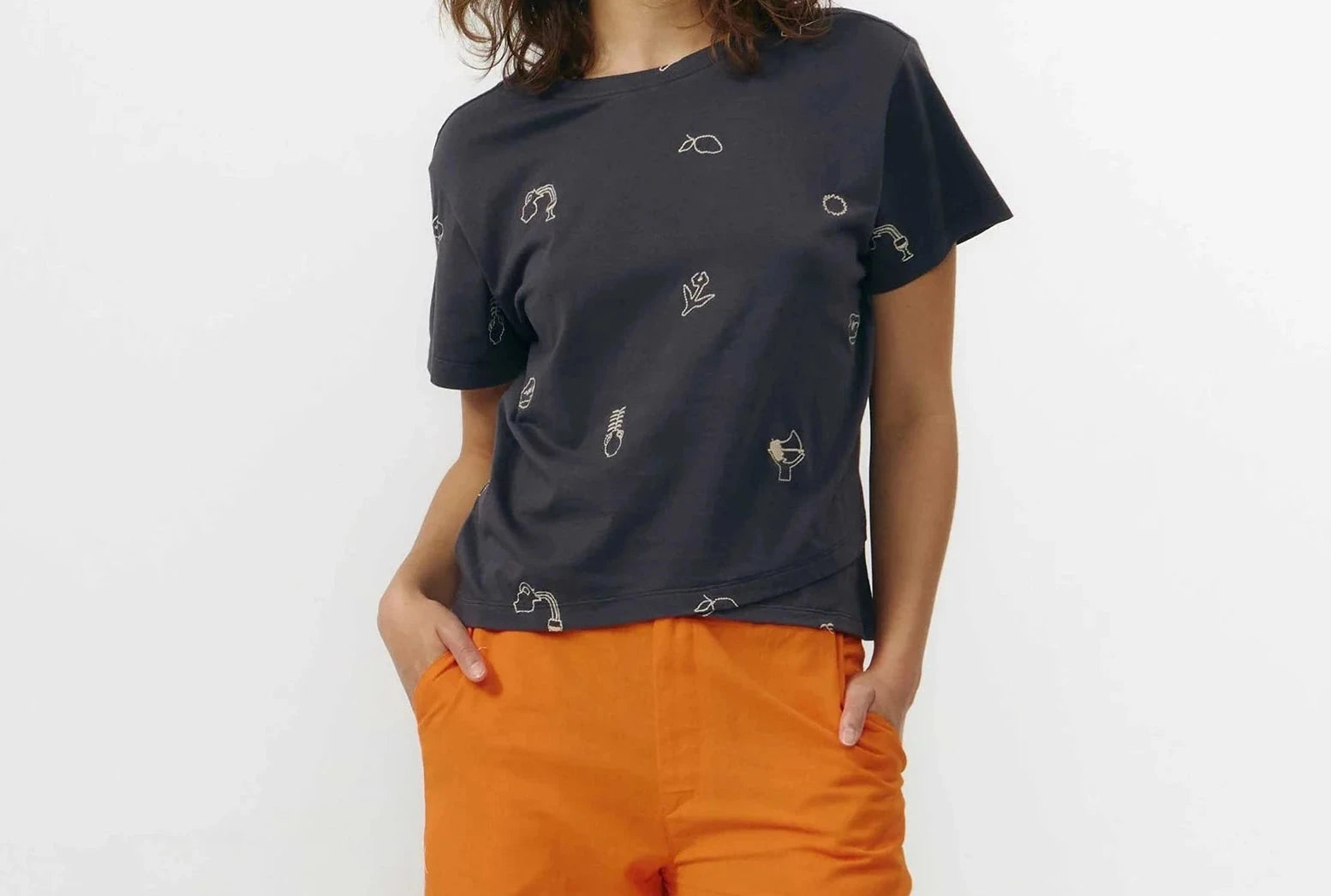 Top de algodón orgánico gris oscuro de manga corta con bordados decorativos, cuello redondo delantero y escote en pico en la espalda de la marca Suite13 Lab.