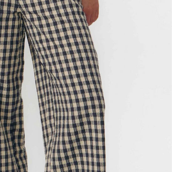 Pantalón culotte de pernera ancha con estampado de cuadros en tonos grises y blancos, talle alto con cintura elástica y bolsillos laterales, hecho en algodón orgánico.