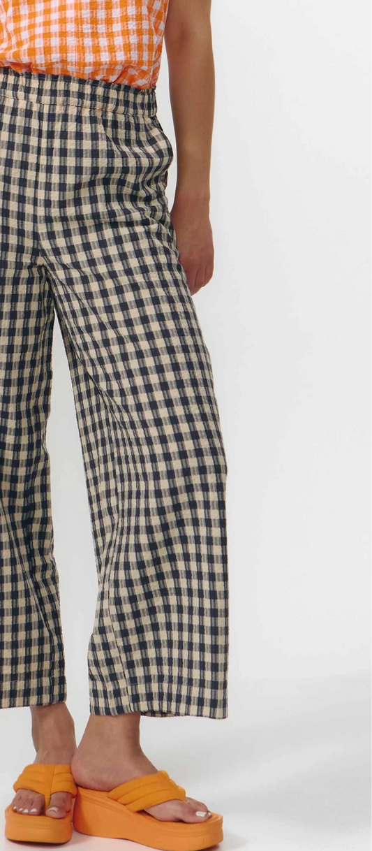 Pantalón culotte de pernera ancha con estampado de cuadros en tonos grises y blancos, talle alto con cintura elástica y bolsillos laterales, hecho en algodón orgánico.
