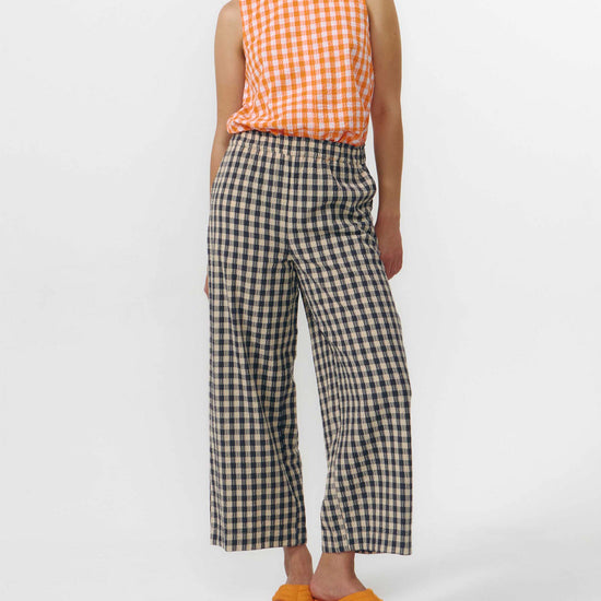 Pantalón culotte de pernera ancha con estampado de cuadros en tonos grises y blancos, talle alto con cintura elástica y bolsillos laterales, hecho en algodón orgánico.
