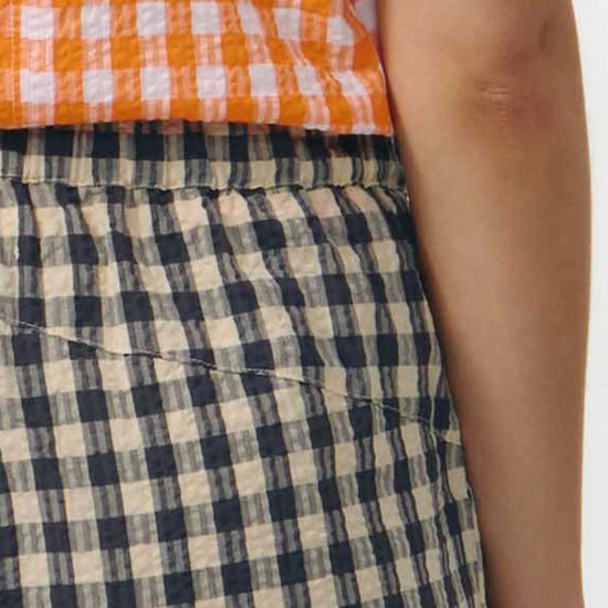 Pantalón culotte de pernera ancha con estampado de cuadros en tonos grises y blancos, talle alto con cintura elástica y bolsillos laterales, hecho en algodón orgánico.