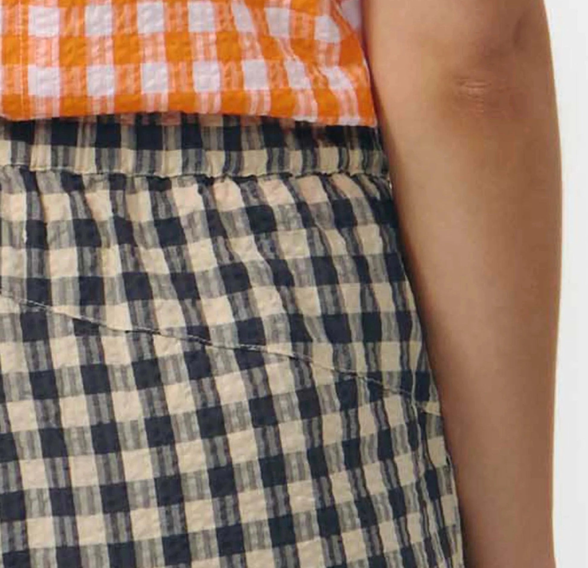 Pantalón culotte de pernera ancha con estampado de cuadros en tonos grises y blancos, talle alto con cintura elástica y bolsillos laterales, hecho en algodón orgánico.