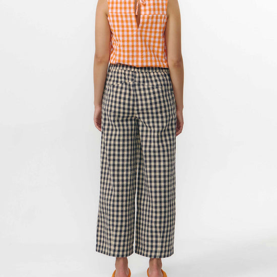 Pantalón culotte de pernera ancha con estampado de cuadros en tonos grises y blancos, talle alto con cintura elástica y bolsillos laterales, hecho en algodón orgánico.