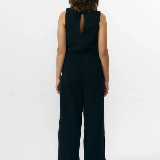 Pantalón de corte culotte en color negro con pernera ancha y corta, talle alto con cintura elástica y bolsillos laterales, fabricado en algodón orgánico.