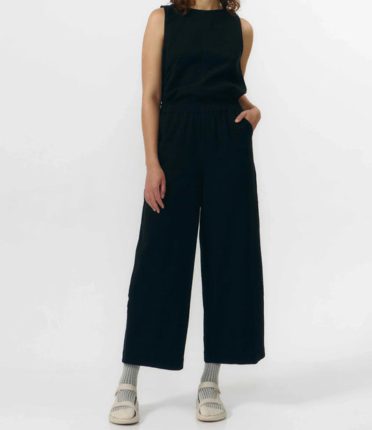 Pantalón de corte culotte en color negro con pernera ancha y corta, talle alto con cintura elástica y bolsillos laterales, fabricado en algodón orgánico.