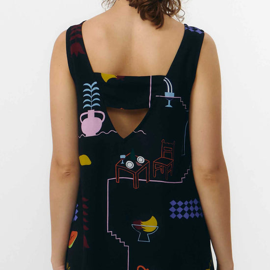 Vestido corto de manga corta con escote en pico y estampado de colores veraniegos sobre fondo blanco, con cierre de botones naturales en el frontal.