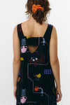 Vestido corto de manga corta con escote en pico y estampado de colores veraniegos sobre fondo blanco, con cierre de botones naturales en el frontal.