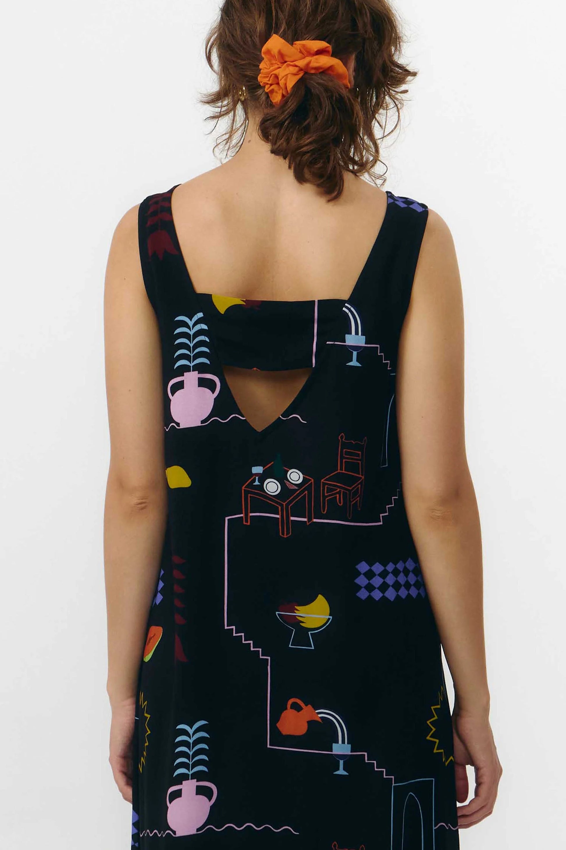 Vestido corto de manga corta con escote en pico y estampado de colores veraniegos sobre fondo blanco, con cierre de botones naturales en el frontal.