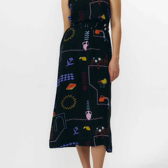 Vestido corto de manga corta con escote en pico y estampado de colores veraniegos sobre fondo blanco, con cierre de botones naturales en el frontal.