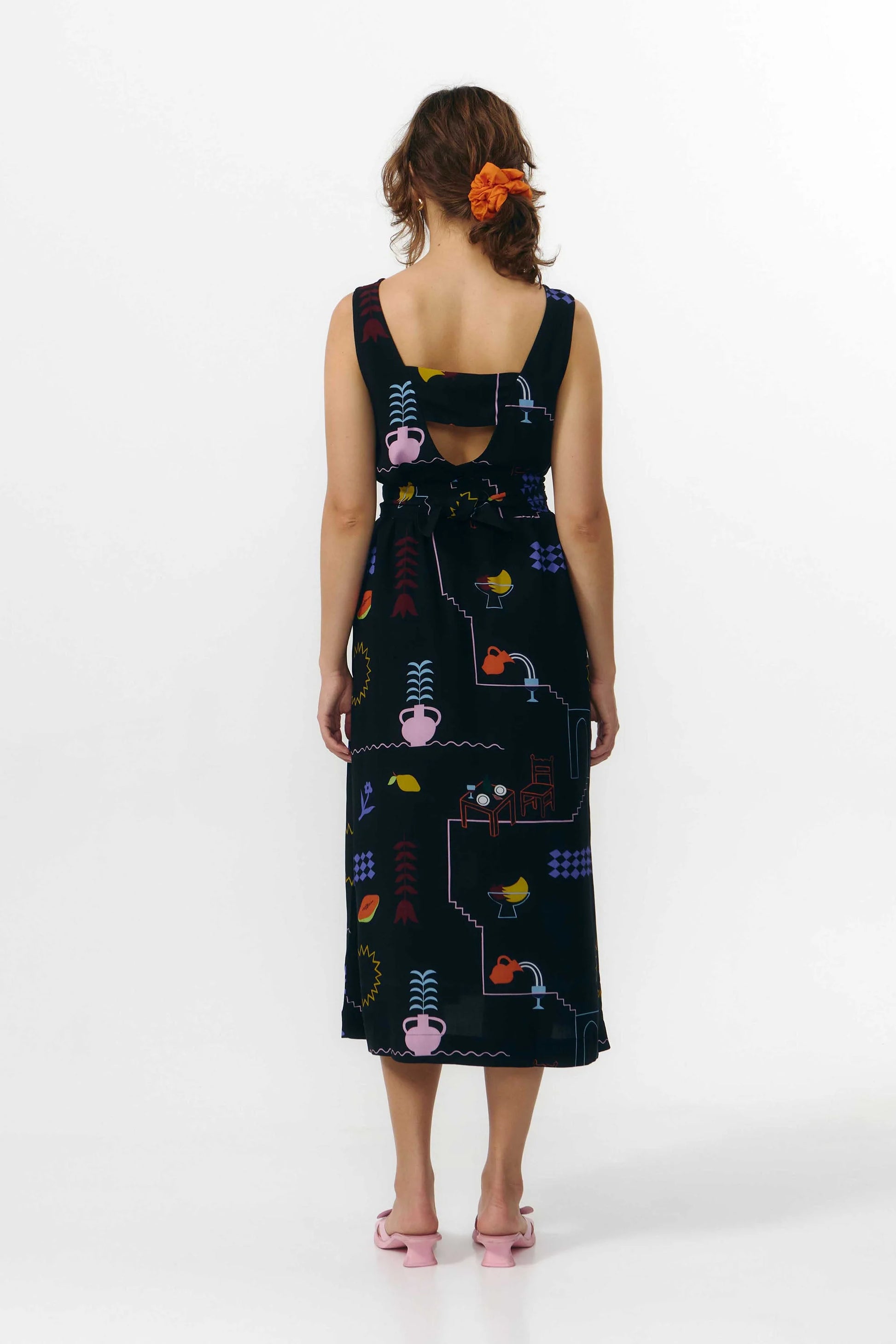 Vestido corto de manga corta con escote en pico y estampado de colores veraniegos sobre fondo blanco, con cierre de botones naturales en el frontal.