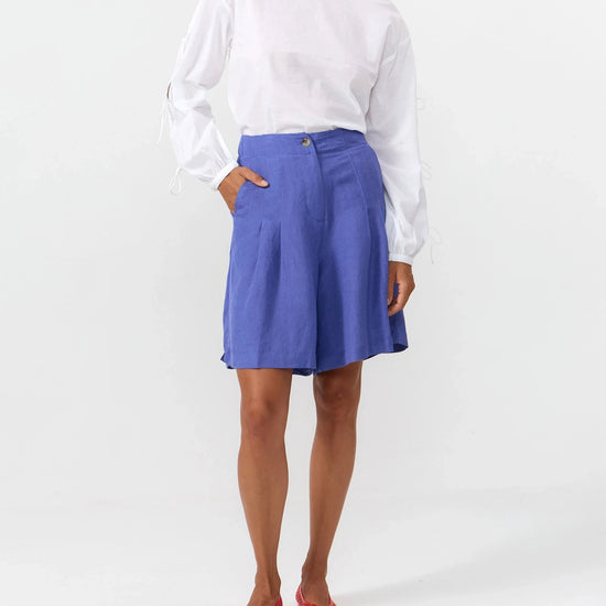 Blusa de manga larga en color blanco con cuello redondo, cierre trasero y mangas con lazos.