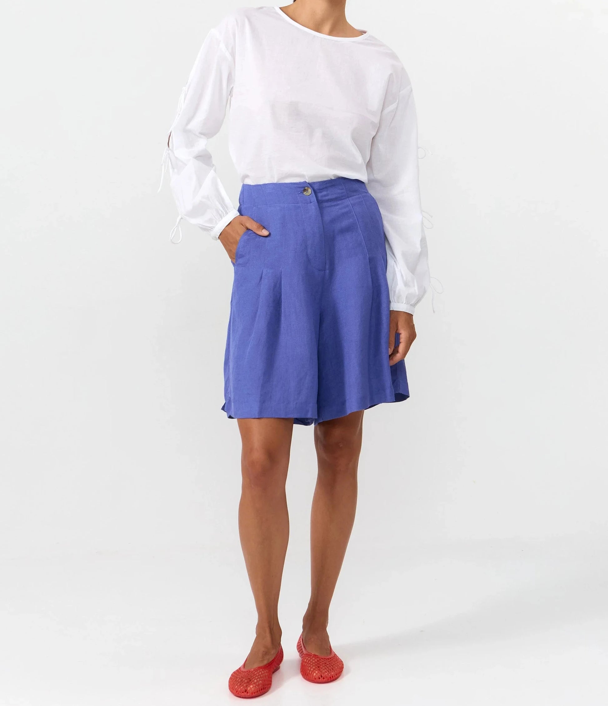 Blusa de manga larga en color blanco con cuello redondo, cierre trasero y mangas con lazos.