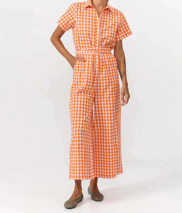Mono largo de manga corta con estampado de cuadros en color naranja y blanco, cuello camisero, botones de corozo y cinturón ajustable de la marca Suite13 Lab.
