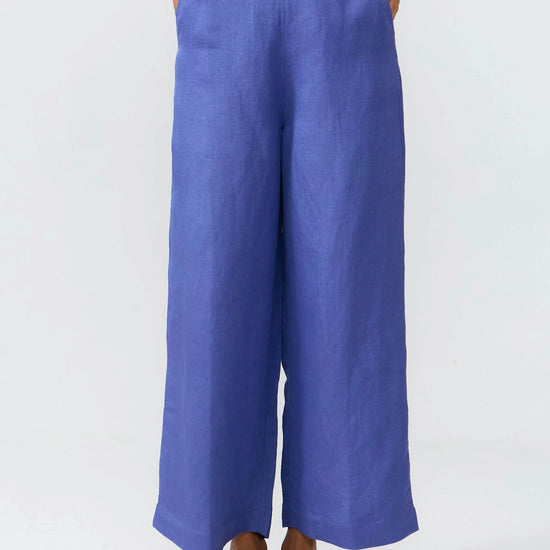 Pantalones de corte culotte en color azul medio con pernera ancha, talle alto y bolsillos delanteros, confeccionados en tejido fluido de lino y viscosa.