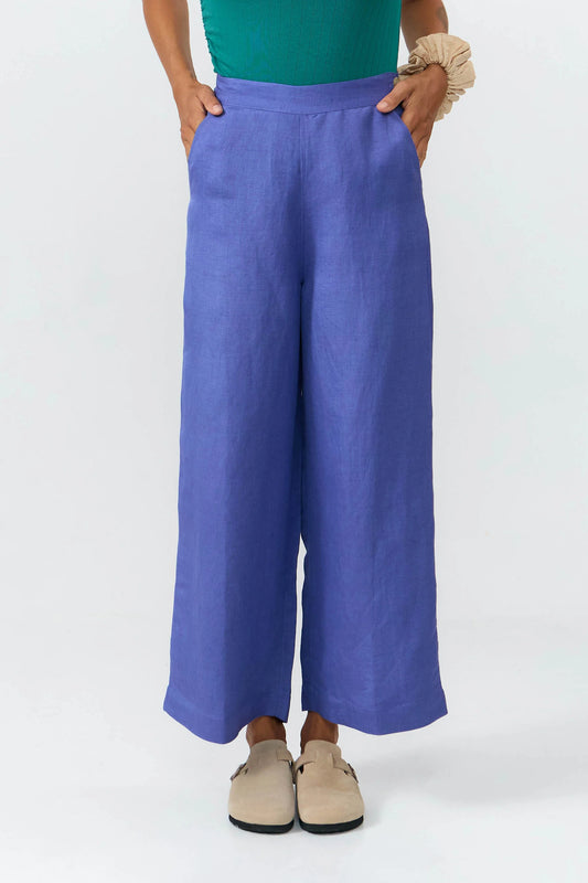 Pantalones de corte culotte en color azul medio con pernera ancha, talle alto y bolsillos delanteros, confeccionados en tejido fluido de lino y viscosa.