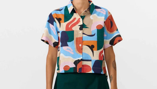 Camisa de manga corta para mujer con estampado Cruise en tonos suaves, corte boxy entallado, cuello de solapas y botones de corozo de la marca Suite13 Lab.